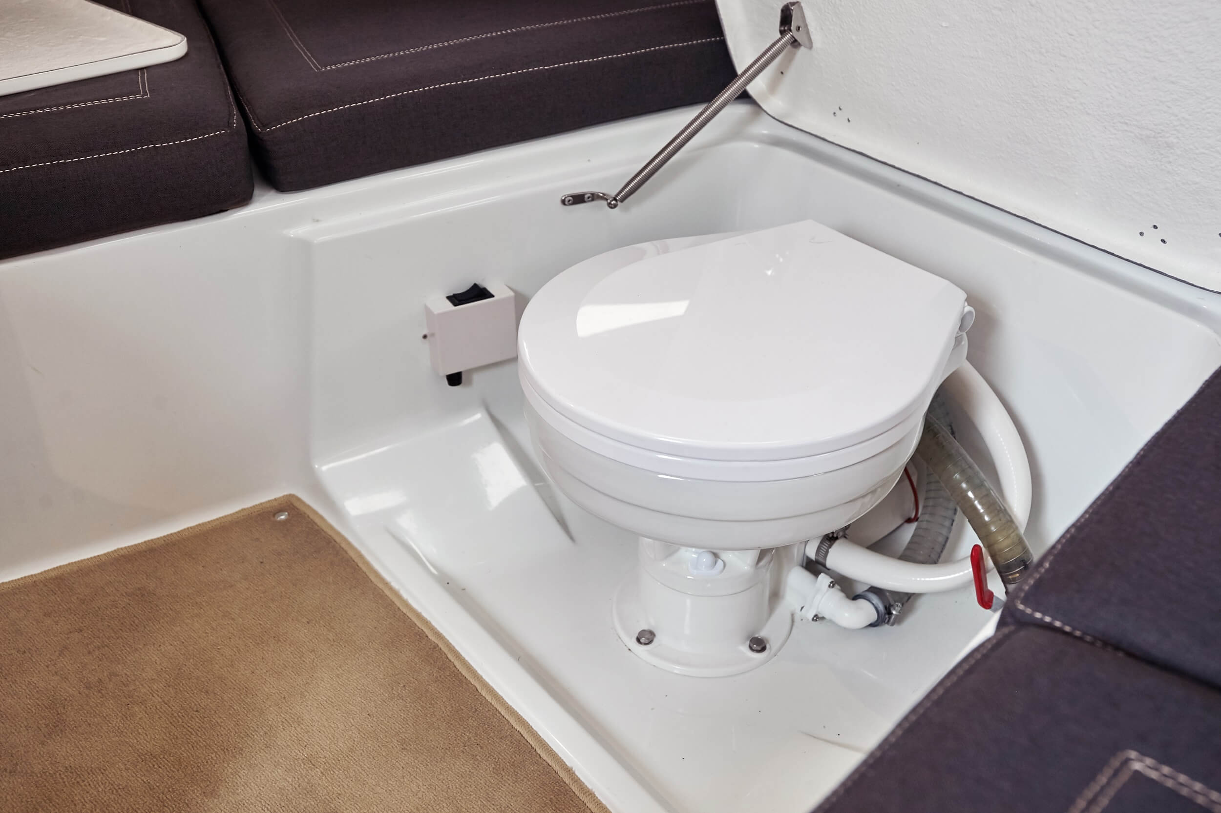 Electric marine toilet under V-sofa